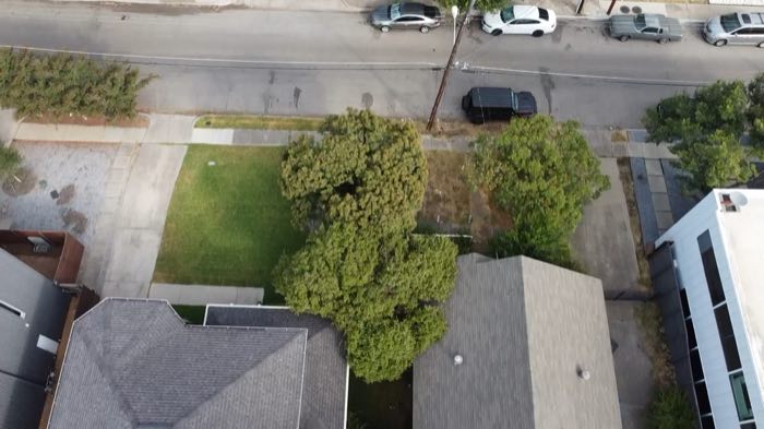 Straight-down aerial over the Deere Street frontage showing both lots, the sidewalk and the street.