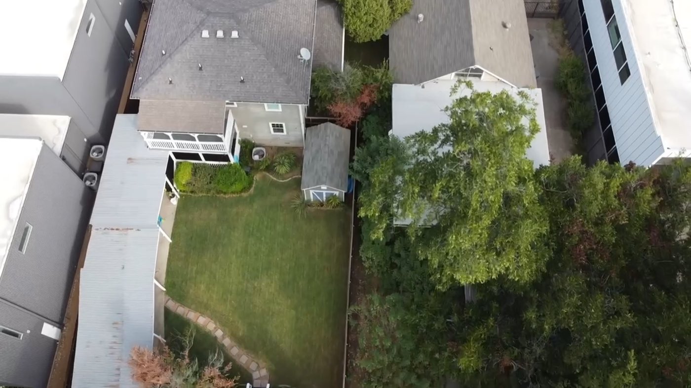 Aerial still from the site flyover, looking straight down over the rear yards of both lots.